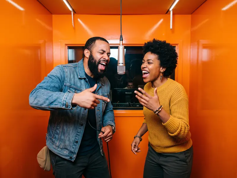 Orange Booth stage: a bright orange studio booth with a hanging microphone