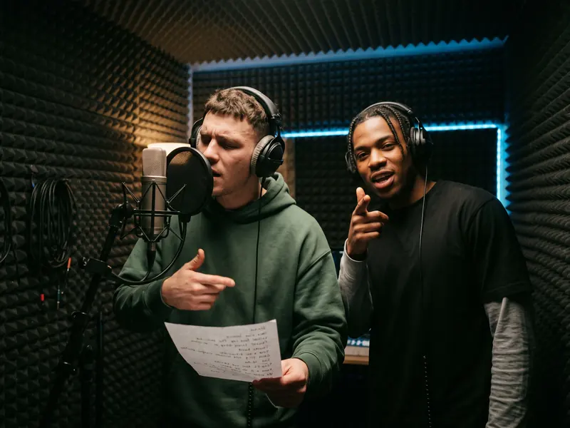 Studio Booth stage: a dark recording booth with acoustic foam and a studio microphone